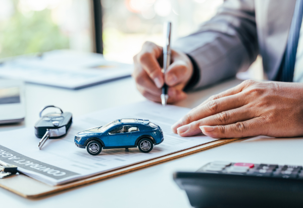 Man,Signing,Car,Insurance,Document,Or,Lease,Paper.,Writing,Signature Man signing car insurance document or lease paper. Writing signature on contract or agreement. Buying or selling new or used vehicle. Car keys on table. Warranty or guarantee. Customer or salesman.